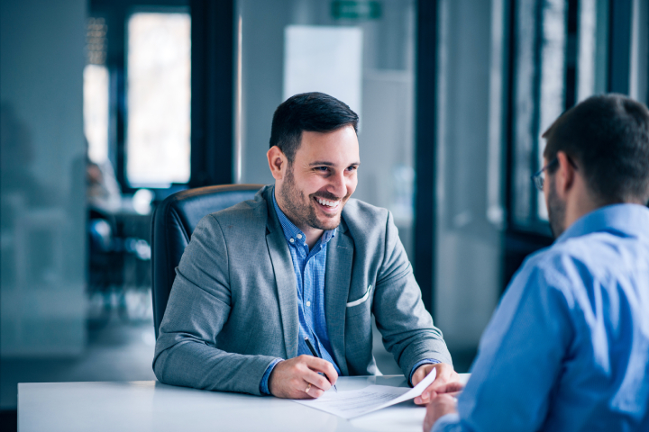 handsome-male-client-signing-document-meeting